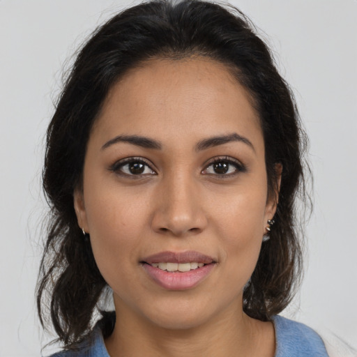 Joyful latino young-adult female with medium  brown hair and brown eyes