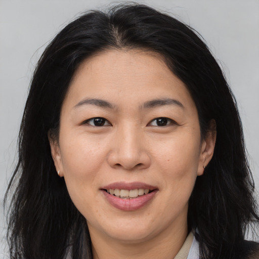 Joyful asian adult female with long  brown hair and brown eyes