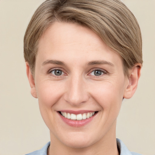 Joyful white young-adult female with short  brown hair and grey eyes