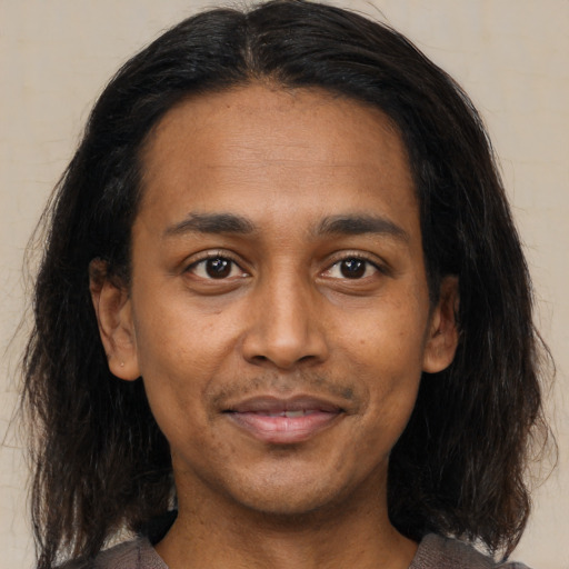 Joyful latino adult male with medium  brown hair and brown eyes