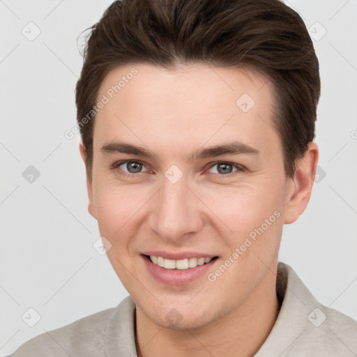 Joyful white young-adult male with short  brown hair and grey eyes