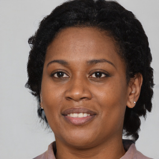 Joyful black young-adult female with medium  brown hair and brown eyes