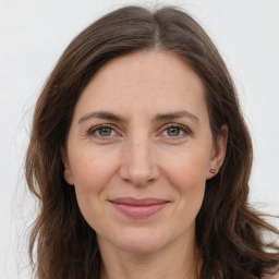 Joyful white adult female with long  brown hair and brown eyes