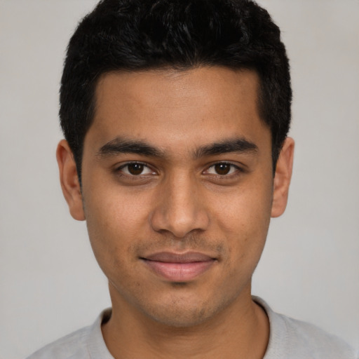 Joyful latino young-adult male with short  black hair and brown eyes