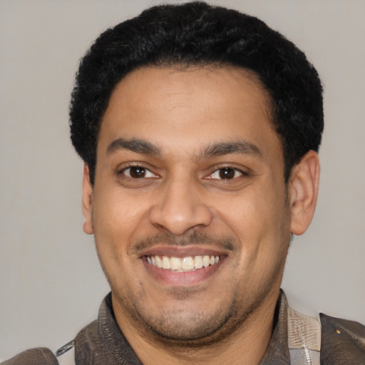 Joyful latino young-adult male with short  black hair and brown eyes