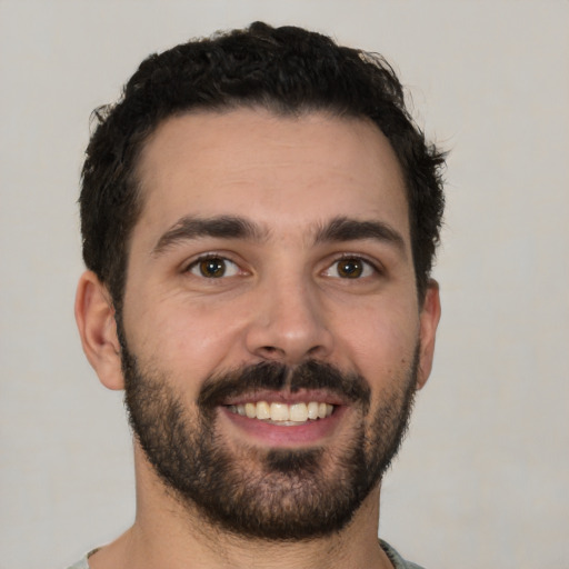 Joyful white young-adult male with short  black hair and brown eyes