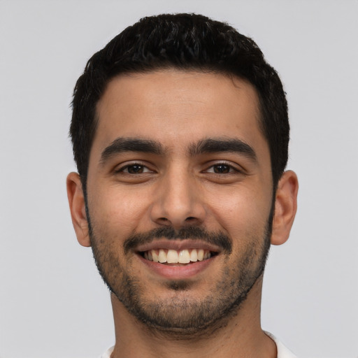 Joyful latino young-adult male with short  black hair and brown eyes