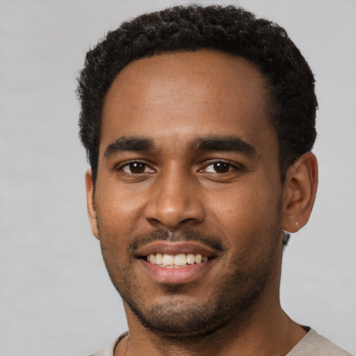 Joyful black young-adult male with short  black hair and brown eyes