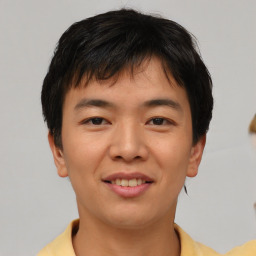 Joyful asian young-adult male with short  brown hair and brown eyes