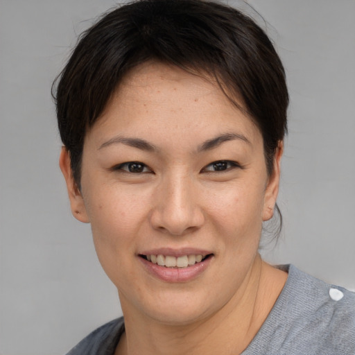 Joyful asian young-adult female with short  brown hair and brown eyes