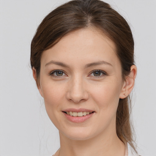 Joyful white young-adult female with medium  brown hair and grey eyes