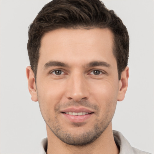 Joyful white young-adult male with short  brown hair and brown eyes