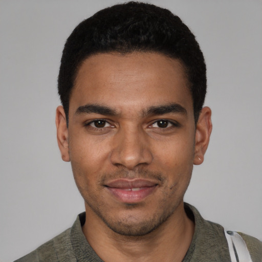 Joyful black young-adult male with short  black hair and brown eyes