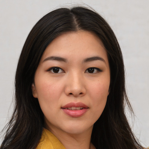 Joyful asian young-adult female with long  brown hair and brown eyes