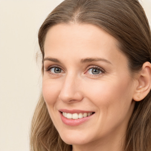 Joyful white young-adult female with long  brown hair and brown eyes