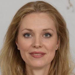 Joyful white young-adult female with long  brown hair and blue eyes