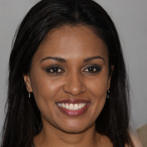 Joyful black young-adult female with long  brown hair and brown eyes
