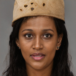 Joyful black young-adult female with long  brown hair and brown eyes