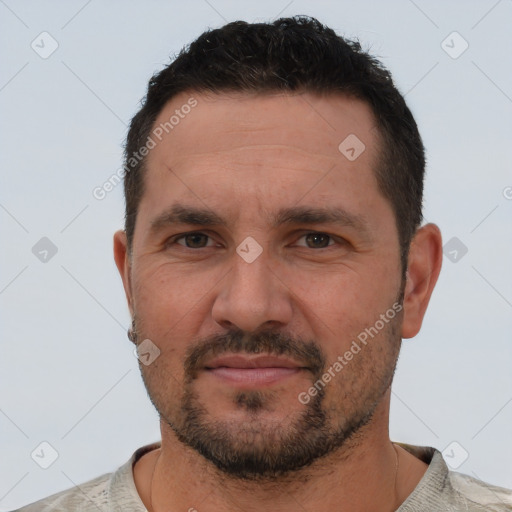 Joyful white adult male with short  black hair and brown eyes