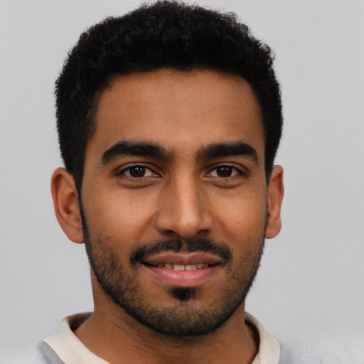 Joyful latino young-adult male with short  black hair and brown eyes