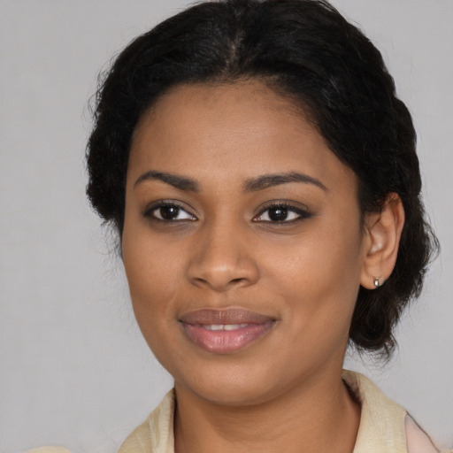 Joyful black young-adult female with medium  brown hair and brown eyes