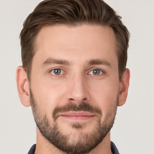 Joyful white young-adult male with short  brown hair and grey eyes