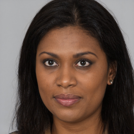 Joyful black young-adult female with long  brown hair and brown eyes