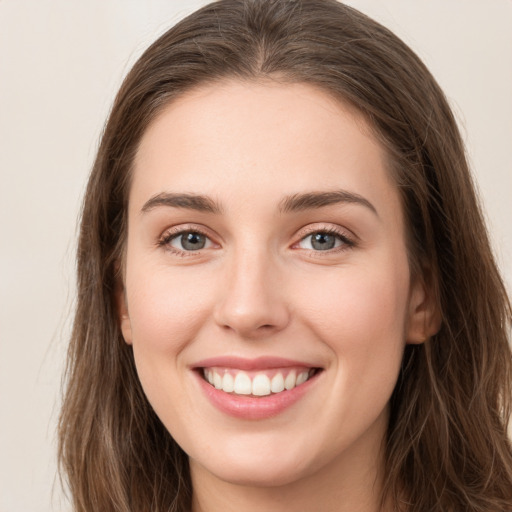 Joyful white young-adult female with long  brown hair and green eyes