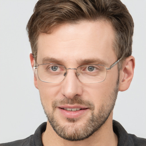 Joyful white adult male with short  brown hair and grey eyes