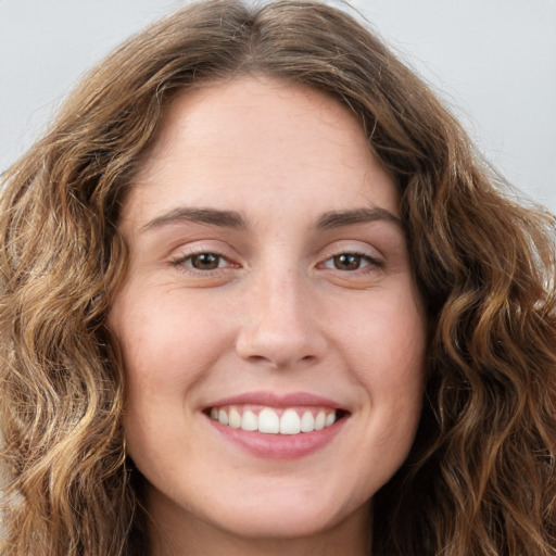 Joyful white young-adult female with long  brown hair and green eyes