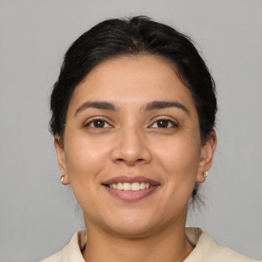 Joyful latino young-adult female with short  brown hair and brown eyes