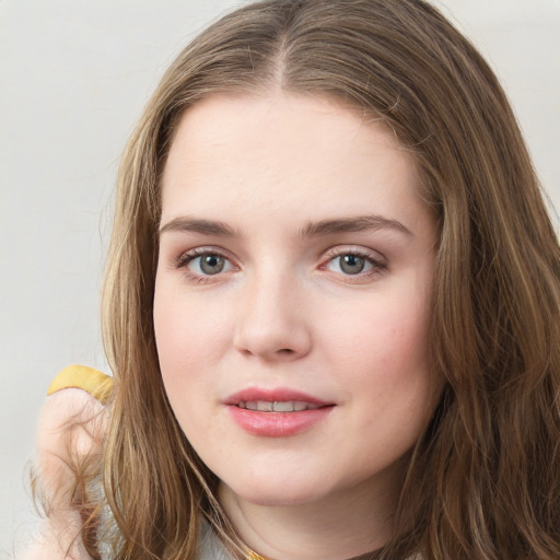 Joyful white young-adult female with long  brown hair and green eyes