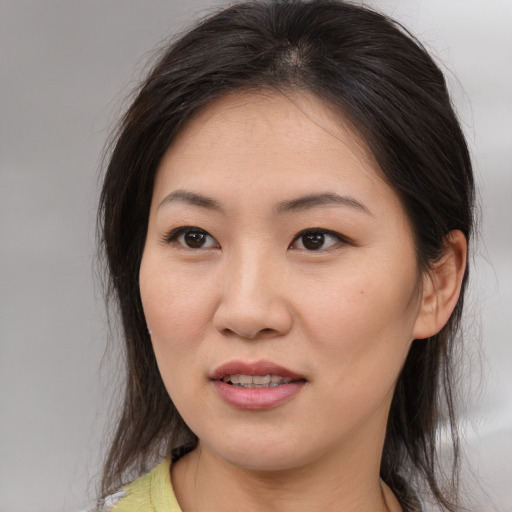 Joyful asian young-adult female with medium  brown hair and brown eyes