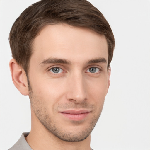 Joyful white young-adult male with short  brown hair and grey eyes