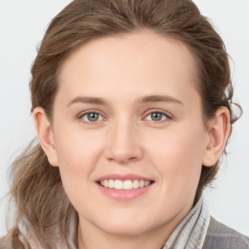 Joyful white young-adult female with medium  brown hair and grey eyes