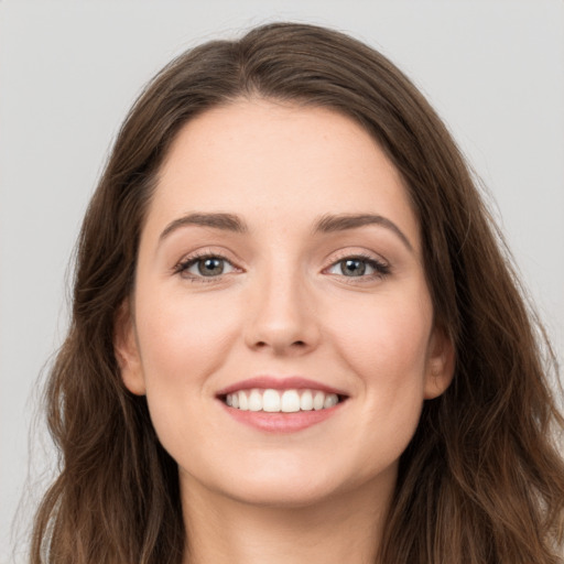 Joyful white young-adult female with long  brown hair and green eyes