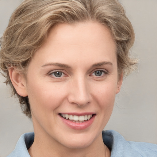 Joyful white young-adult female with medium  brown hair and blue eyes