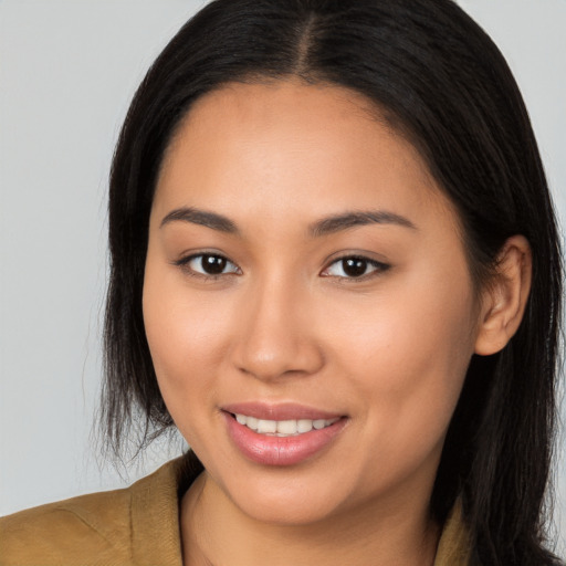 Joyful latino young-adult female with long  brown hair and brown eyes