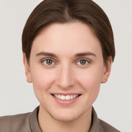 Joyful white young-adult female with short  brown hair and grey eyes