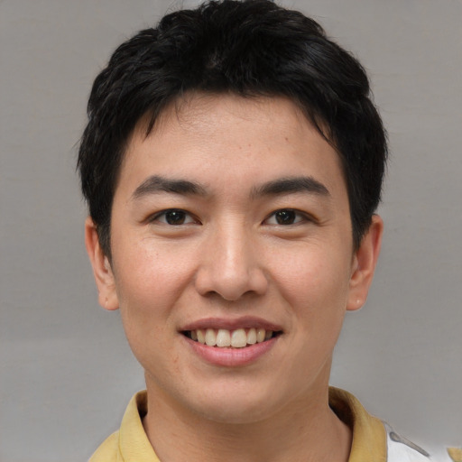 Joyful asian young-adult male with short  brown hair and brown eyes