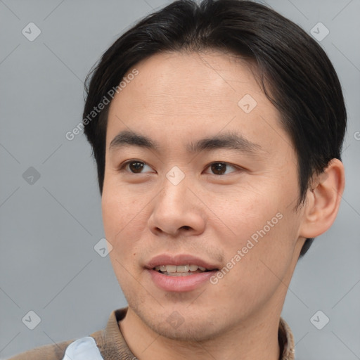 Joyful asian young-adult male with short  brown hair and brown eyes