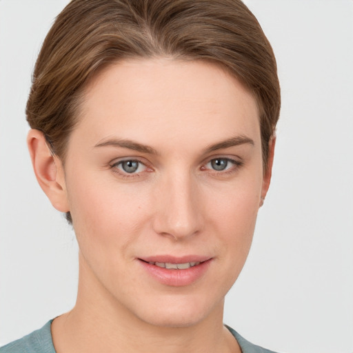 Joyful white young-adult female with short  brown hair and grey eyes