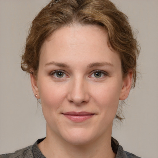 Joyful white young-adult female with medium  brown hair and blue eyes