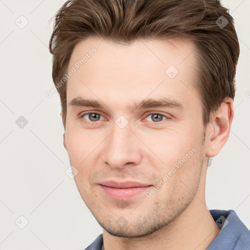 Joyful white young-adult male with short  brown hair and grey eyes