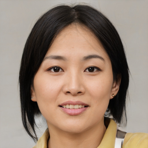 Joyful asian young-adult female with medium  black hair and brown eyes