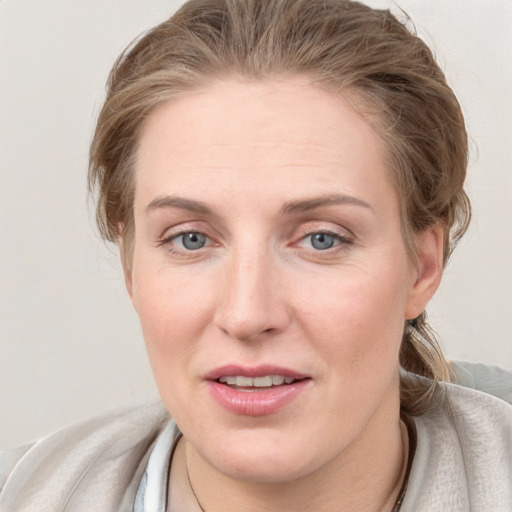 Joyful white young-adult female with medium  brown hair and blue eyes