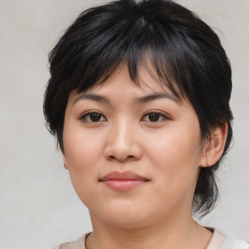 Joyful asian young-adult female with medium  brown hair and brown eyes
