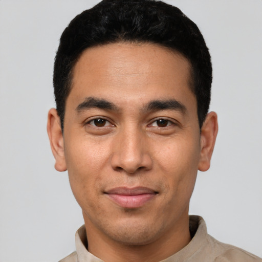 Joyful latino young-adult male with short  black hair and brown eyes