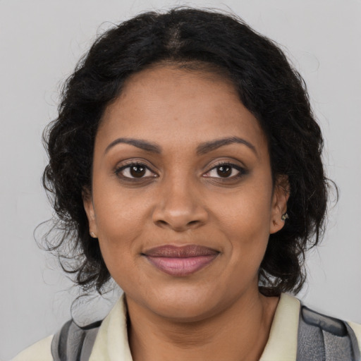 Joyful black young-adult female with medium  brown hair and brown eyes