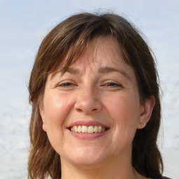 Joyful white adult female with medium  brown hair and grey eyes